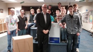 Pictured is Director of Solar Energy Thomas Enzendorfer with the donated inverters and students.